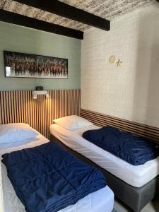 two beds in a room with a wall at Vakantiebungalow nr 7 in het Heuvelland in Simpelveld