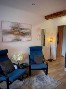 a living room with two chairs and a painting on the wall at Apartment three Rivers2 in Passau