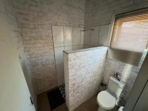 een badkamer met een wit toilet en een douche bij Kaoko Bush Lodge in Kamanjab
