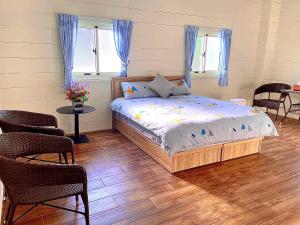 Schlafzimmer mit einem Bett, einem Tisch und Stühlen in der Unterkunft 雲熙莊園 in Renai