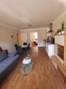 a living room with a blue couch and a kitchen at Pension am Rheinsteig in Leutesdorf