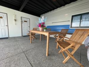 einen Holztisch und Stühle auf einer Terrasse in der Unterkunft 雲熙莊園 in Renai