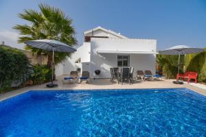 - une piscine avec des chaises et des parasols en face d'une maison dans l'établissement El Boticari, à Dénia