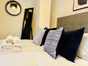 łóżko z czarno-białymi poduszkami i lustrem w obiekcie Modern one bedroom apartment near Old Trafford Stadium w Manchesterze