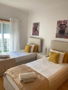 een slaapkamer met twee bedden en een raam bij Apartamento Altumar T2 in Portimão +28 foto's