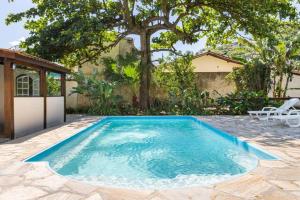 a swimming pool in the middle of a yard at Casa com 6 Suites, piscina e estacionamento in Ilhabela