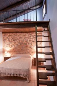1 dormitorio con cama y pared de ladrillo en Apartamentos Cine Capicol, en Albarracín