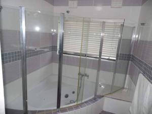 a shower with a glass door in a bathroom at Reflections at 21 in East London