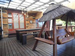 a wooden deck with a bench and an umbrella at Reflections at 21 in East London