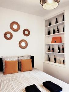 - une chambre avec un lit et des étagères avec des bouteilles dans l'établissement ESCAPADE en CHAMPAGNE, à Épernay