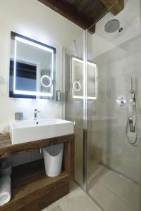 a bathroom with a sink and a glass shower at Hotel Antica Abbazia in Borso del Grappa