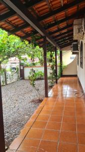 an outdoor patio with awning and a tile floor at Casa praia Enseada in São Francisco do Sul