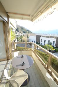 einen Balkon mit einem Tisch und Blick auf das Wasser in der Unterkunft La Costa di Alex in Minusio