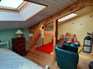 1 dormitorio con altillo con 1 cama y sala de juegos en gîte de Véreuges, en Saint-Julien-des-Chazes