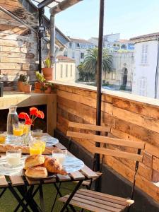 a table with bread and orange juice on a balcony at Le Gambetta - La Rochelle Royale in La Rochelle