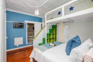 a bedroom with a bed with blue and green walls at Paradise Guest House in Roodepoort