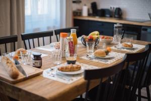 una mesa de madera con comida y bebidas. en La Grande Ferté en La Rochelle