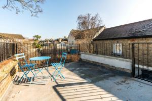 a patio with two chairs and a table on a fence at Spacious Modern 2 Bedroom London Flat in Sydenham
