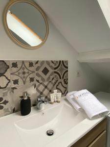 Un baño con un lavabo blanco y un espejo. en Le Loge'Mans, en Le Mans 29 fotos más