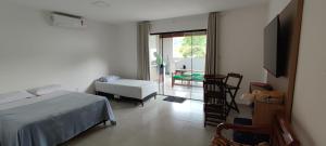 1 dormitorio con 1 cama, 1 mesa y 1 silla en Casa do Sérgio, Lindo loft-02 moderno e confortável., en Paraty