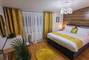 Schlafzimmer mit einem Kingsize-Bett und einem Tisch in der Unterkunft Sun Deluxe Apartment in Banja Luka