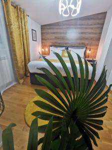 ein Schlafzimmer mit einem Bett und einer Topfpflanze in der Unterkunft Sun Deluxe Apartment in Banja Luka