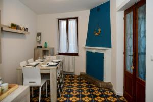 ein Esszimmer mit einem Tisch und einer blauen Wand in der Unterkunft Quadrifoglio Apartment by Wonderful Italy in Bellagio