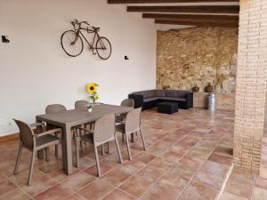 un comedor con mesa y sillas y una bicicleta en la pared en El Callejón, en Vara de Rey
