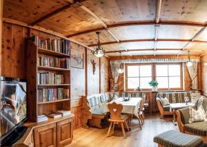 ein Esszimmer mit einem Tisch und Bücherregalen in der Unterkunft Wiesenhof in Kaunerberg