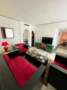 uma sala de estar com mobiliário vermelho e um sofá vermelho em Hôtel Volubilis em Fez