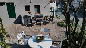 eine Terrasse mit einem Tisch und Stühlen mit Blumen darauf in der Unterkunft Quadrifoglio Apartment by Wonderful Italy in Bellagio