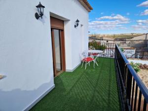 een balkon met een tafel en groen gras bij El Callejón in Vara de Rey