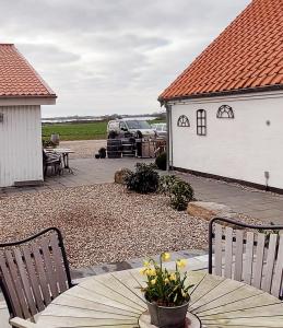 un patio con tavolo, sedie e un edificio di Skovby 2 a Skovby