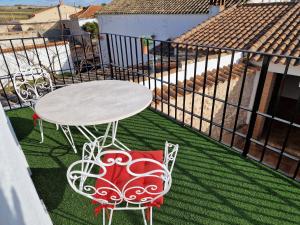 een tafel en stoelen op een balkon met een tafel bij El Callejón in Vara de Rey