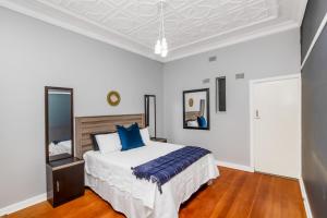 a bedroom with a large bed with blue pillows at Paradise Guest House in Roodepoort