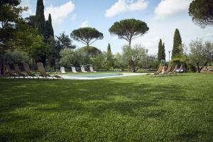 a group of chairs sitting on the grass in a park at Le Balze Camere in Villa in Perugia