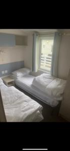 2 Betten in einem Zimmer mit Fenster in der Unterkunft Seaside chill in Prestatyn