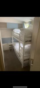 a small room with two bunk beds and a window at Seaside chill in Prestatyn