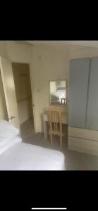 a bedroom with a bed and a desk and a mirror at Seaside chill in Prestatyn