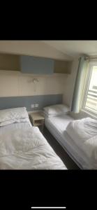 two beds in a room with a window at Seaside chill in Prestatyn