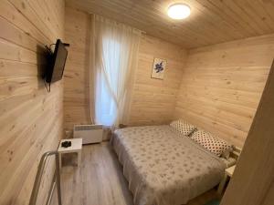 - une chambre avec un lit dans un mur en bois dans l'établissement Затишний будинок в передмісті Києва, à Kriukivshchyna