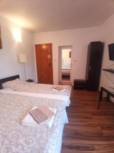 - une chambre d'hôtel avec 2 lits et un livre sur le lit dans l'établissement Стаи за гости Алба, à Kazanlak