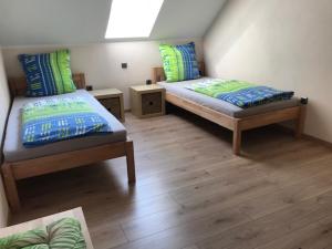 Duas camas num quarto com pisos em madeira em Ferienwohnung Anna mit Blick ins Grüne em Moosbach
