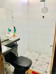 a bathroom with a black toilet and a sink at Casa em Barreirinhas 01 in Barreirinhas +54 photos