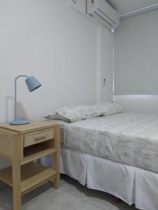 1 dormitorio con 1 cama y mesita de noche con lámpara en Alquiler temporario Céntrico La Plata en La Plata