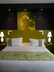 um quarto com uma cama grande e um quadro na parede em Golf Hotel Colvert - Room Service Disponible em Levernois