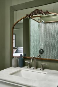 un lavandino da bagno con un grande specchio sopra di Blind Tiger Portland - Carleton Street a Portland