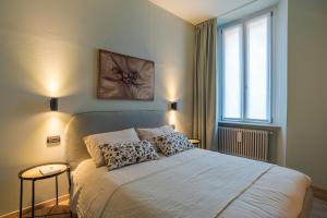um quarto com uma cama com duas almofadas e uma janela em Cernobbio Charming APT! em Cernobbio