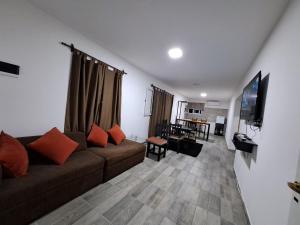 sala de estar con sofá y TV de pantalla plana en La Mora en Salta