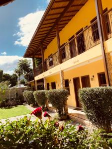 un edificio amarillo con balcón y algunas flores en Pousada Luamar, en Paraty